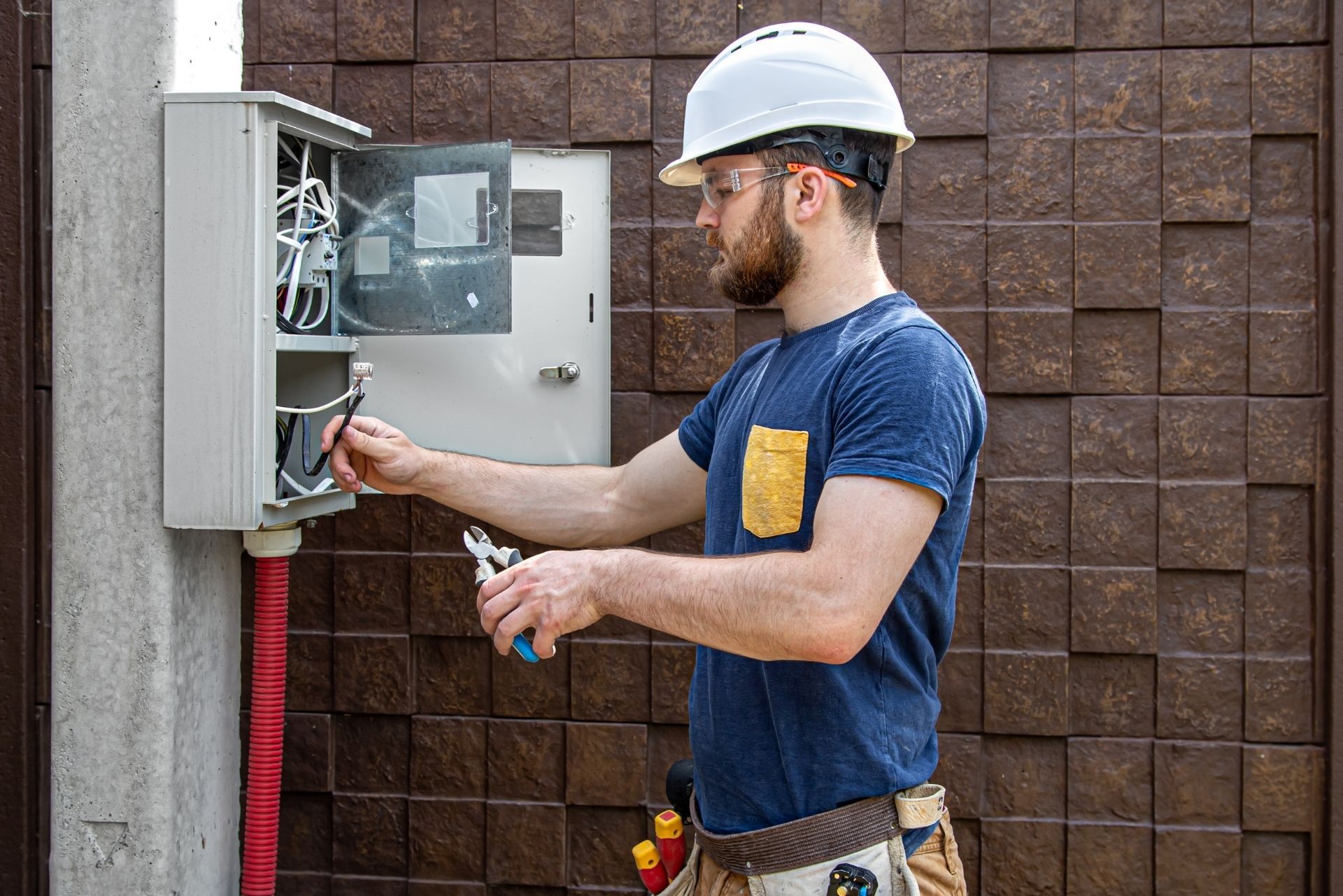 HVAC technician wearing mask and hard hat, working on AC units on a rooftop. HVAC technician wearing mask and hard hat, working on AC units on a rooftop.