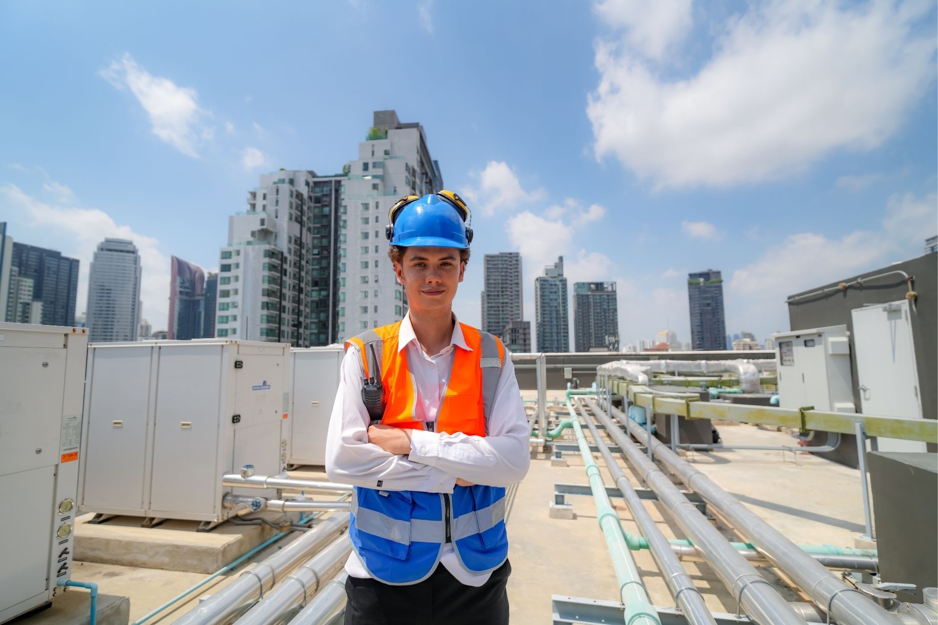 HVAC technician wearing mask and hard hat, working on AC units on a rooftop. HVAC technician wearing mask and hard hat, working on AC units on a rooftop.