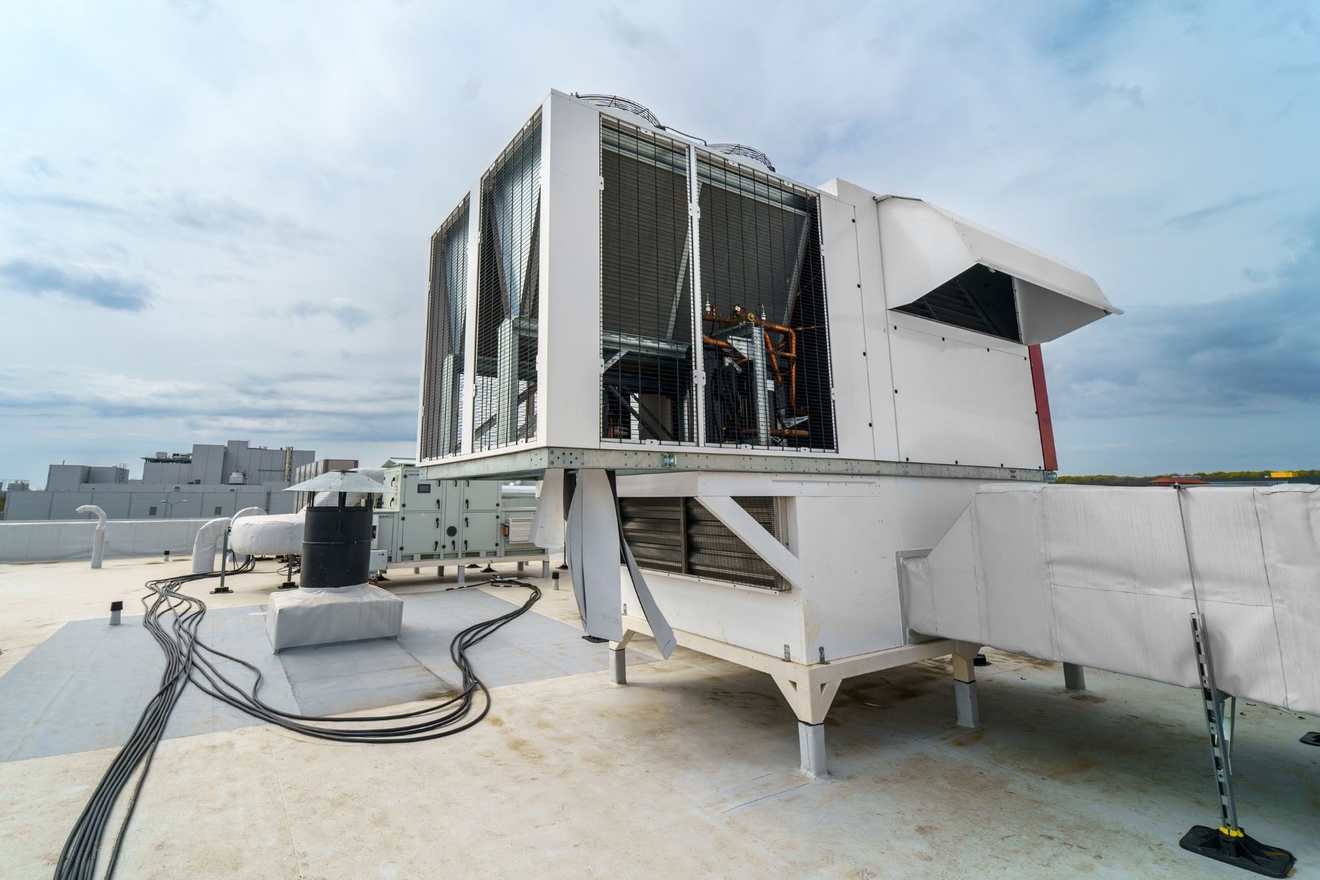 HVAC technician wearing mask and hard hat, working on AC units on a rooftop. HVAC technician wearing mask and hard hat, working on AC units on a rooftop.