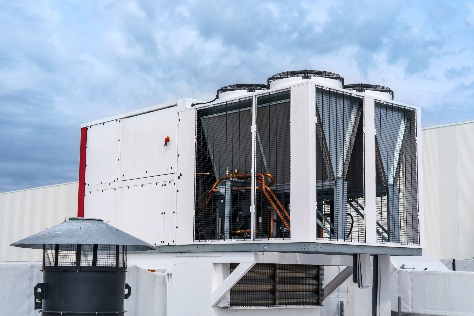HVAC technician wearing mask and hard hat, working on AC units on a rooftop. HVAC technician wearing mask and hard hat, working on AC units on a rooftop.
