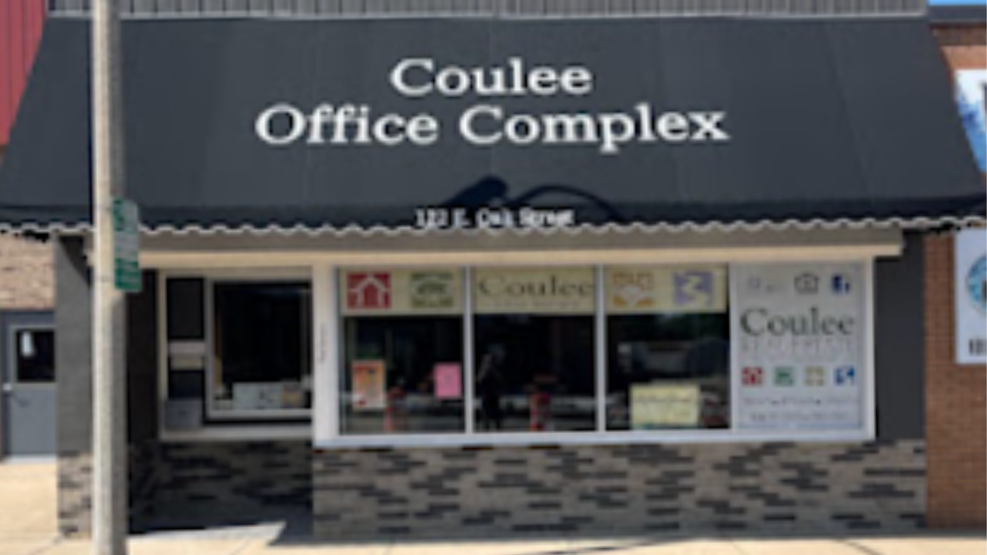 Storefront sign reading “Coulee Office Complex” above a glass entrance with awning.