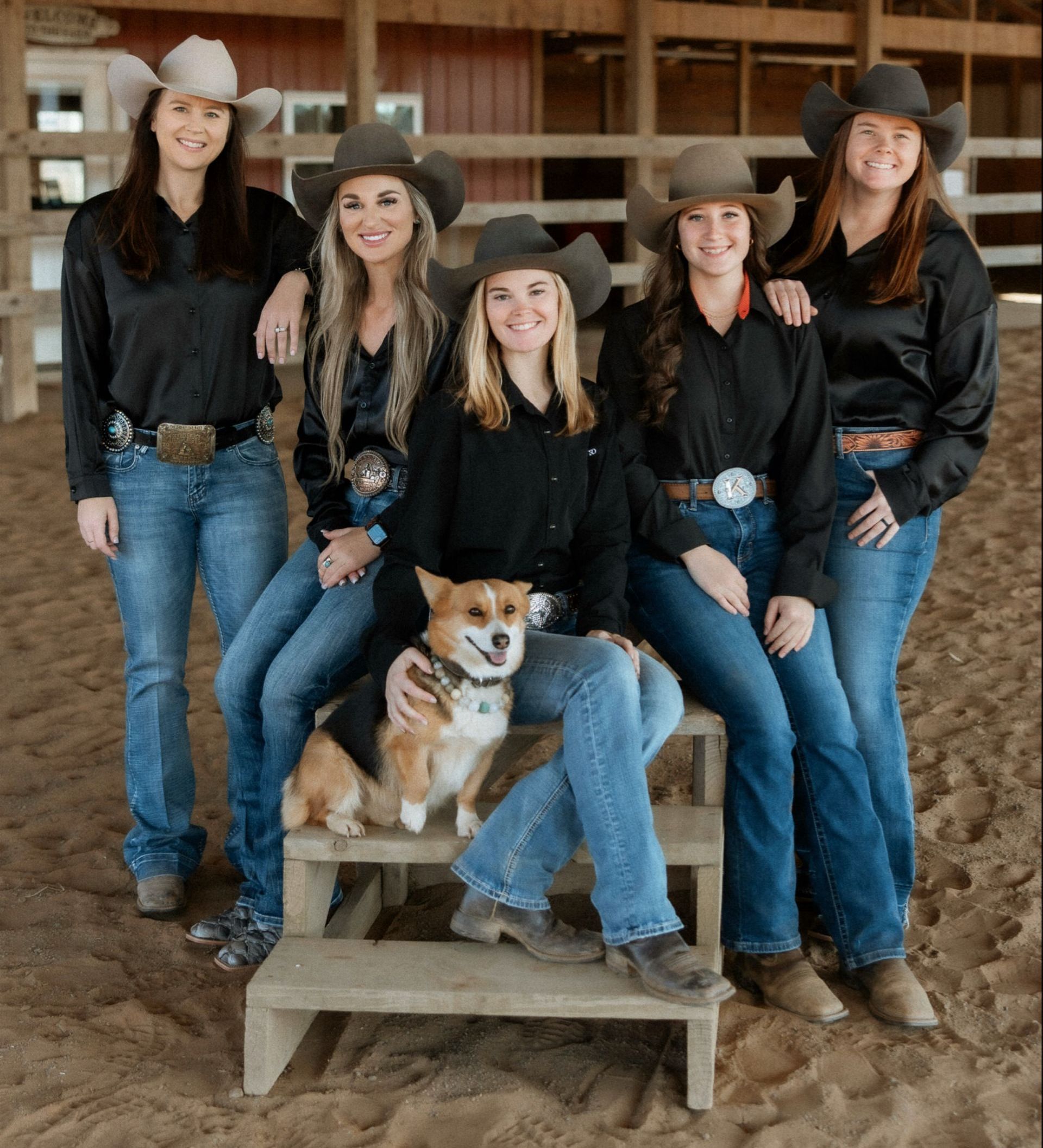 A group of women are posing for a picture with a dog