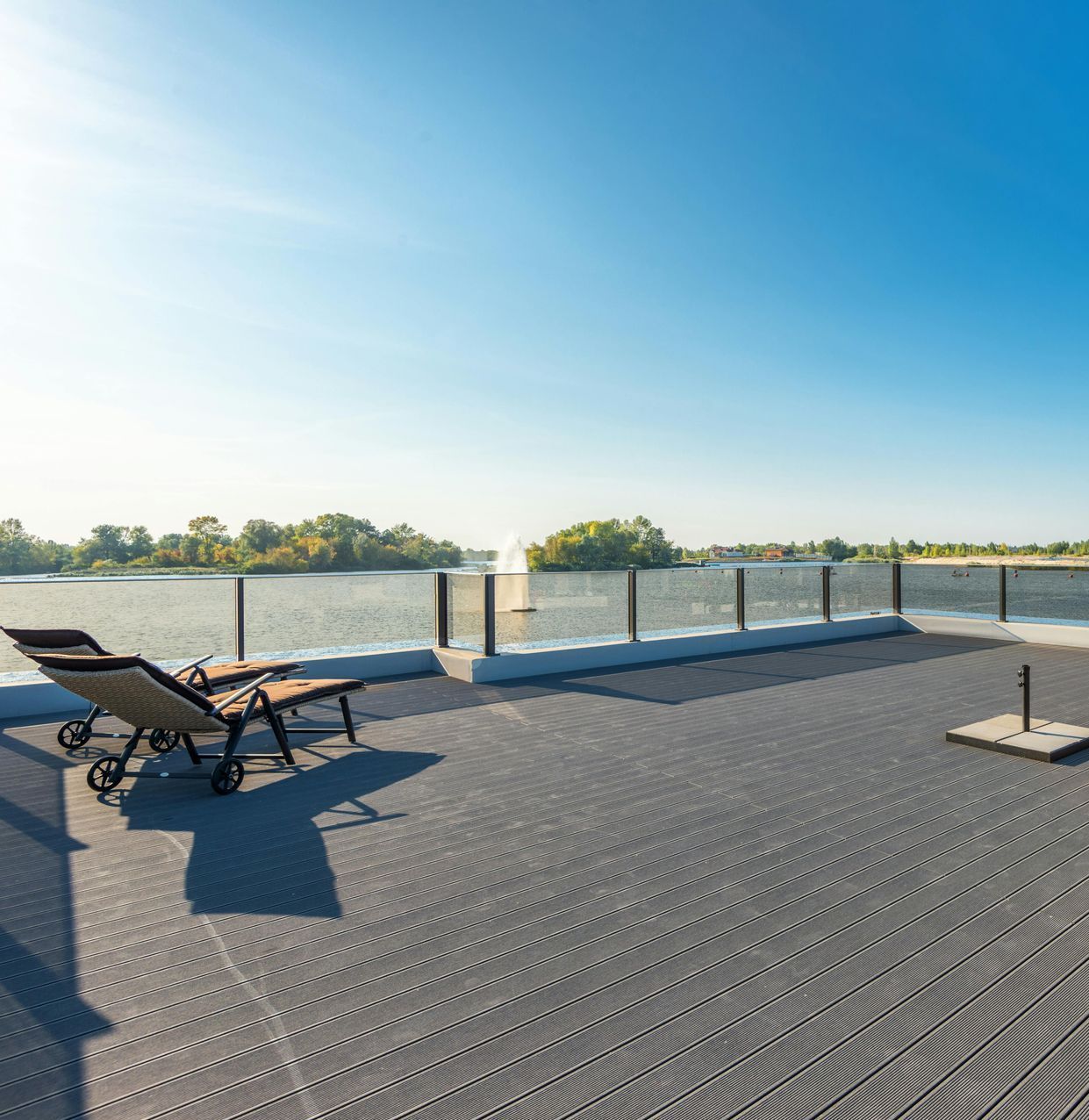 composite deck by lake with glass railing