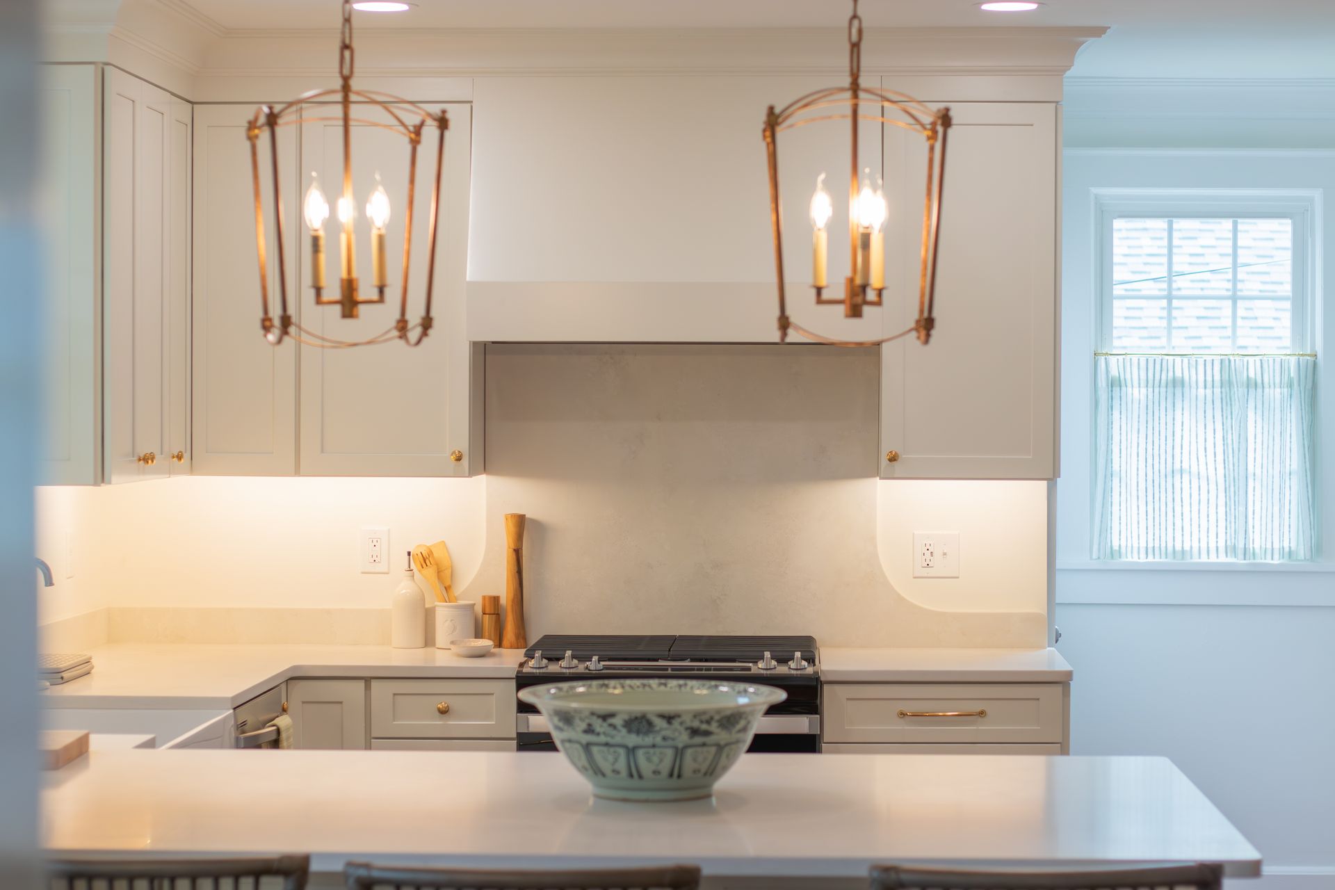 Bright modern kitchen with white cabinets, pendant lights, and a gray island counter