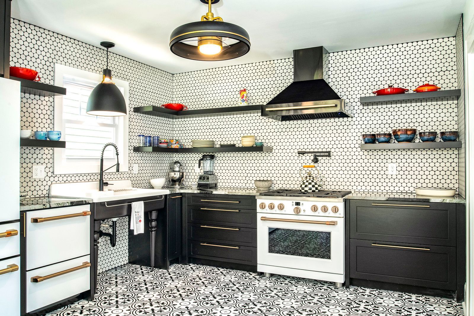 Bright modern kitchen with white patterned walls, black cabinets, open shelves, and red accents
