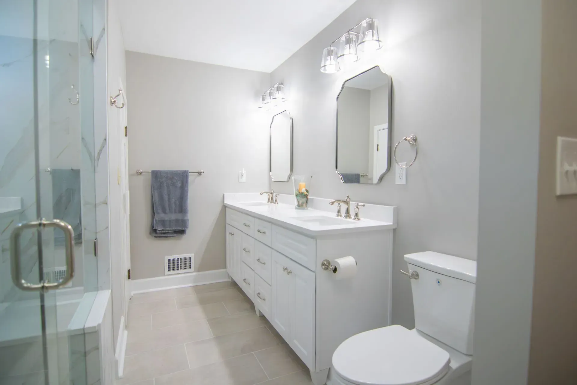 Bathroom remodel in Greenville, South Carolina: white vanity glass shower door