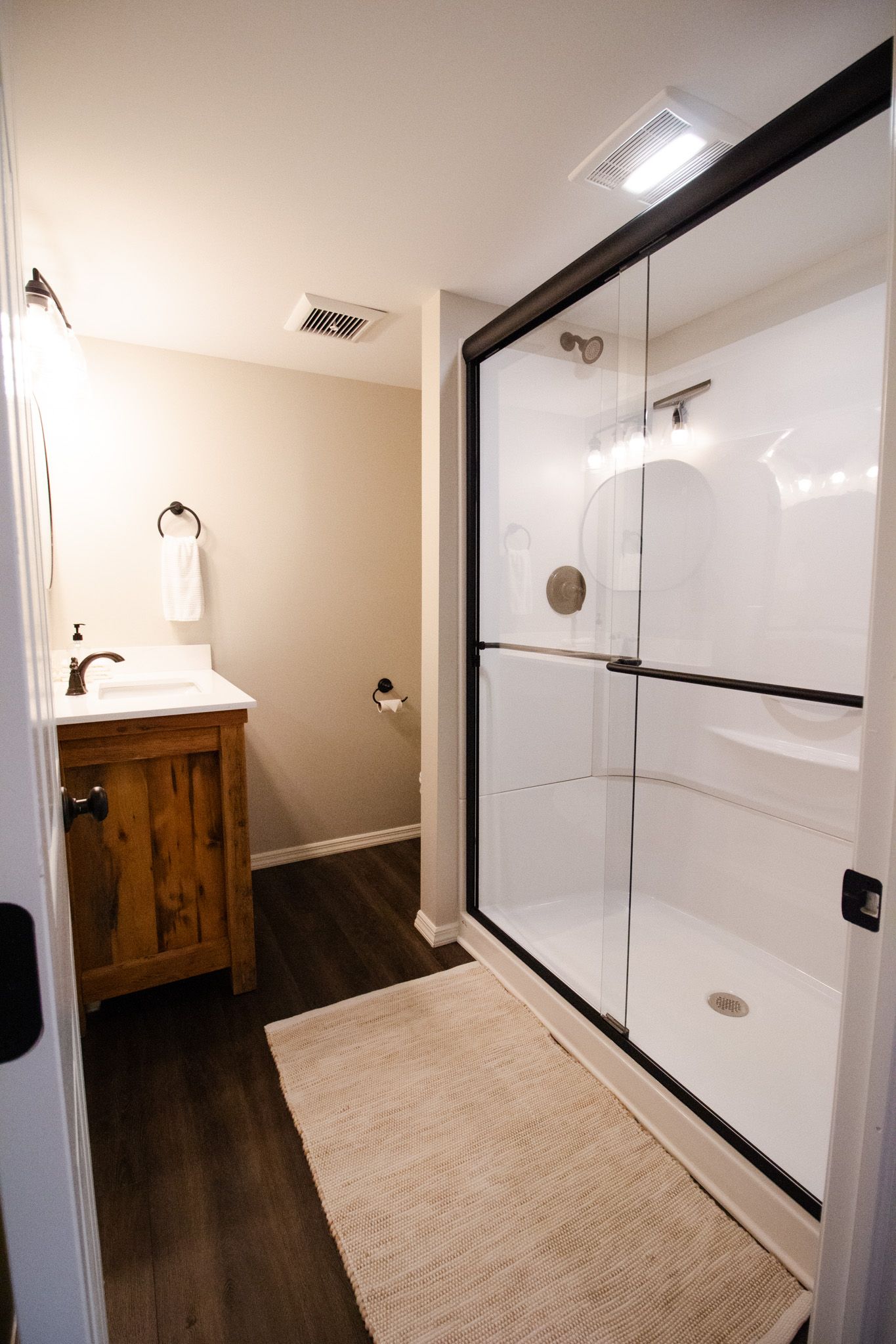 A bathroom with a sink and a walk in shower.
