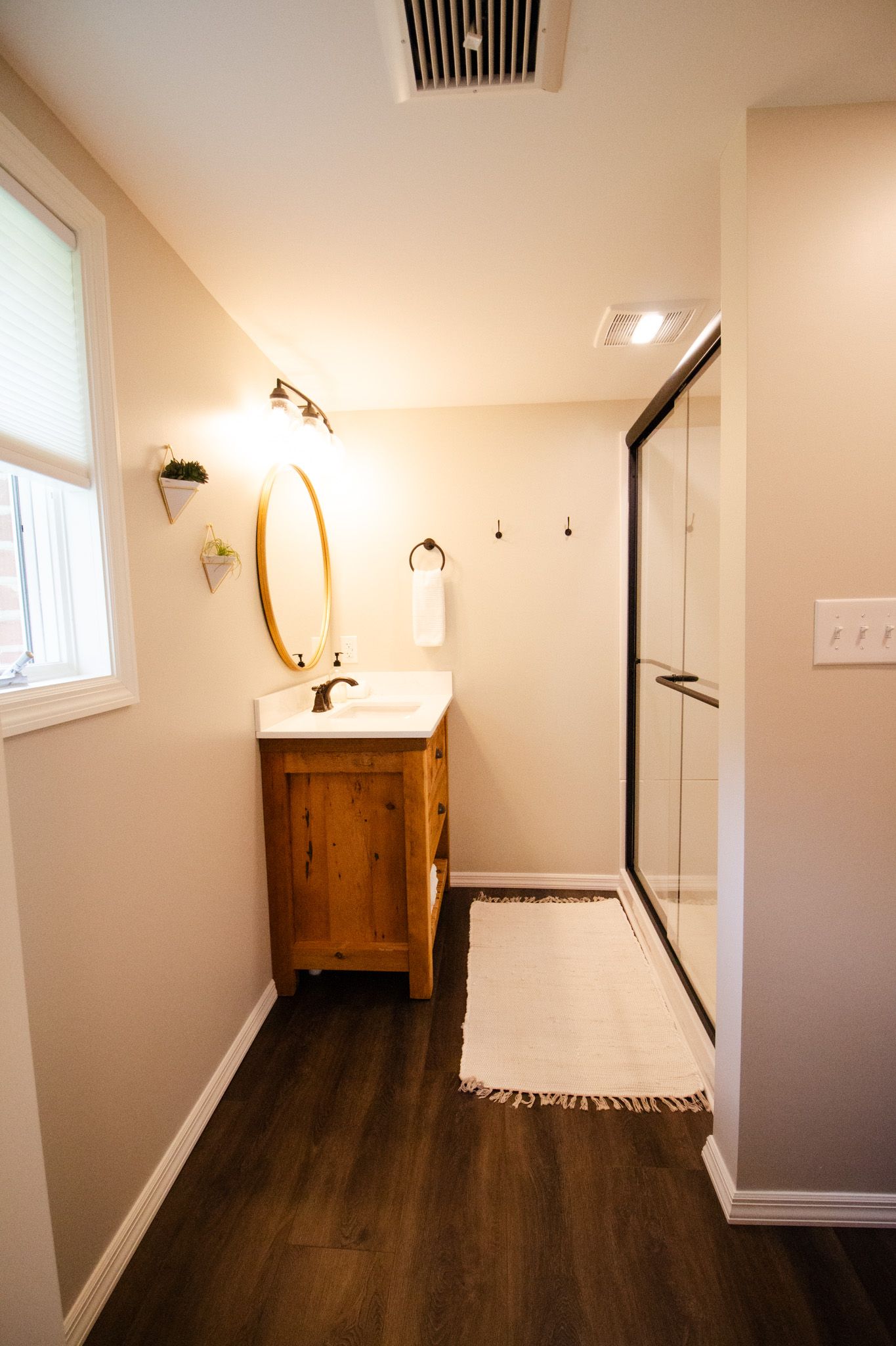 A bathroom with a sink , mirror , and walk in shower.