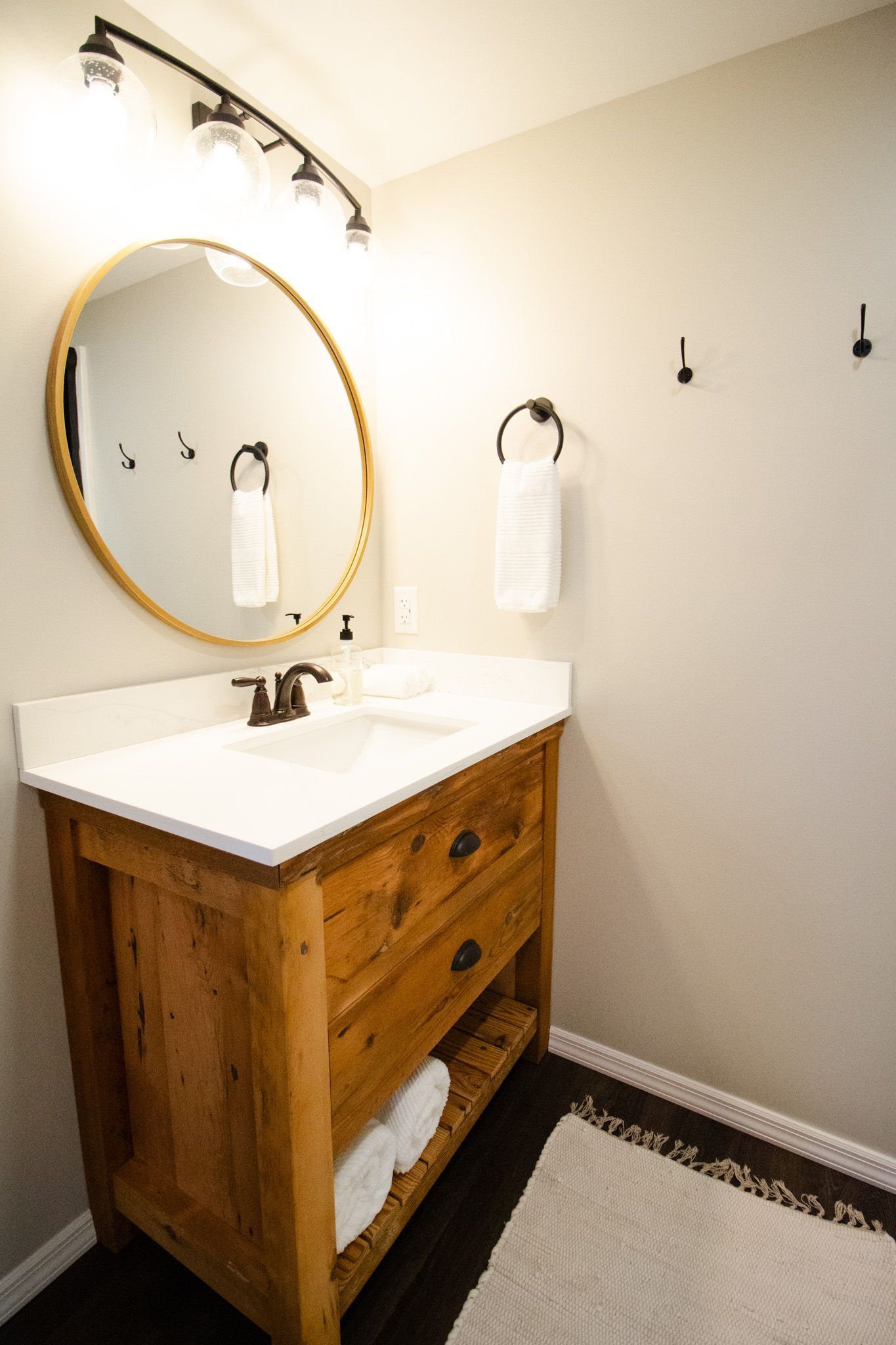 A bathroom with a sink , mirror and towel rack.