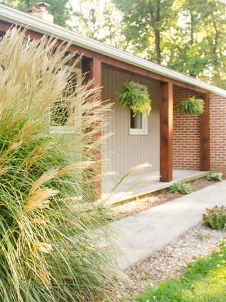 A house with a porch and a brick wall A house with a porch and a brick wall