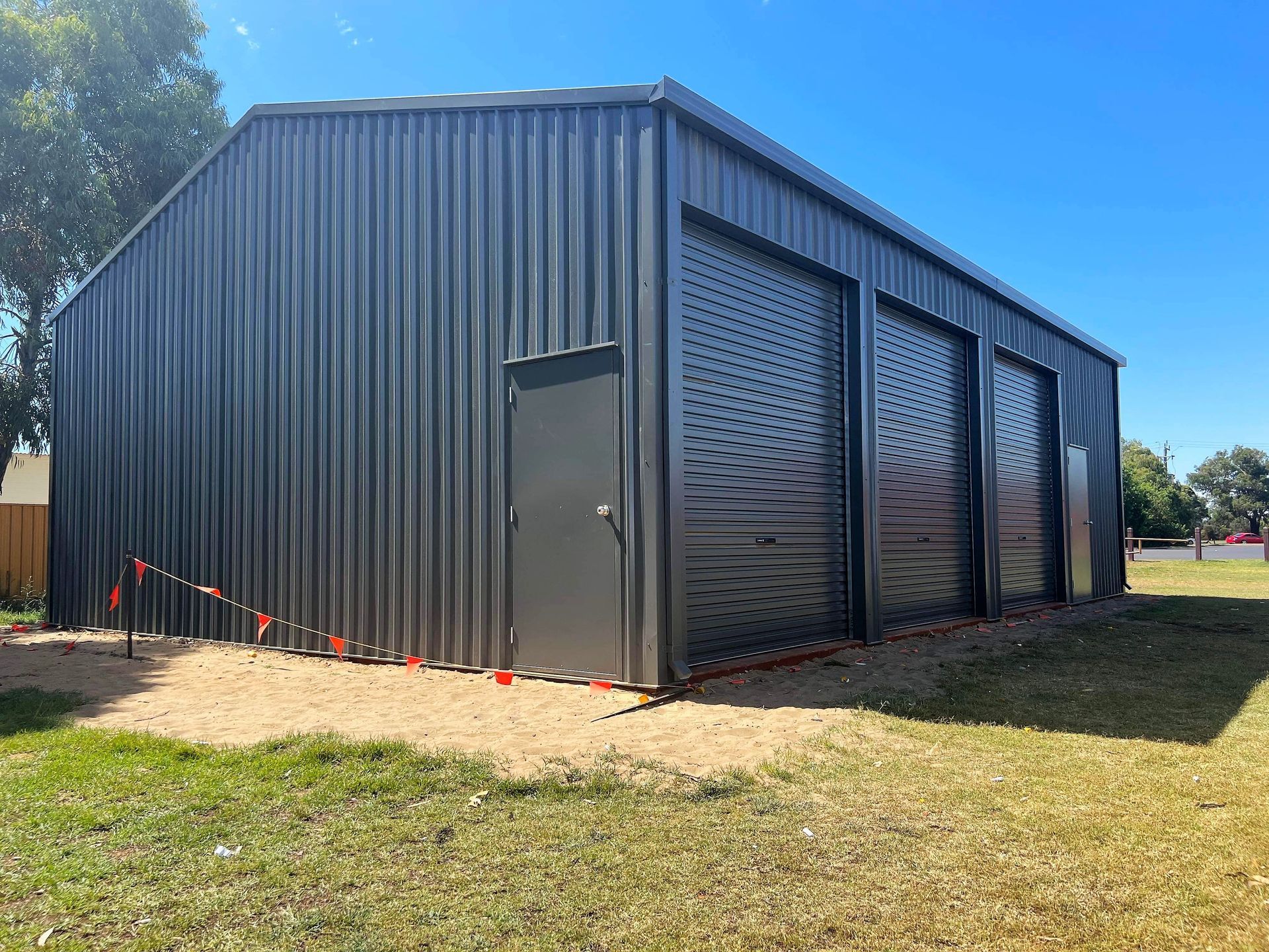 A sunny day on a farm in a green countryside yard with different-sized sheds.