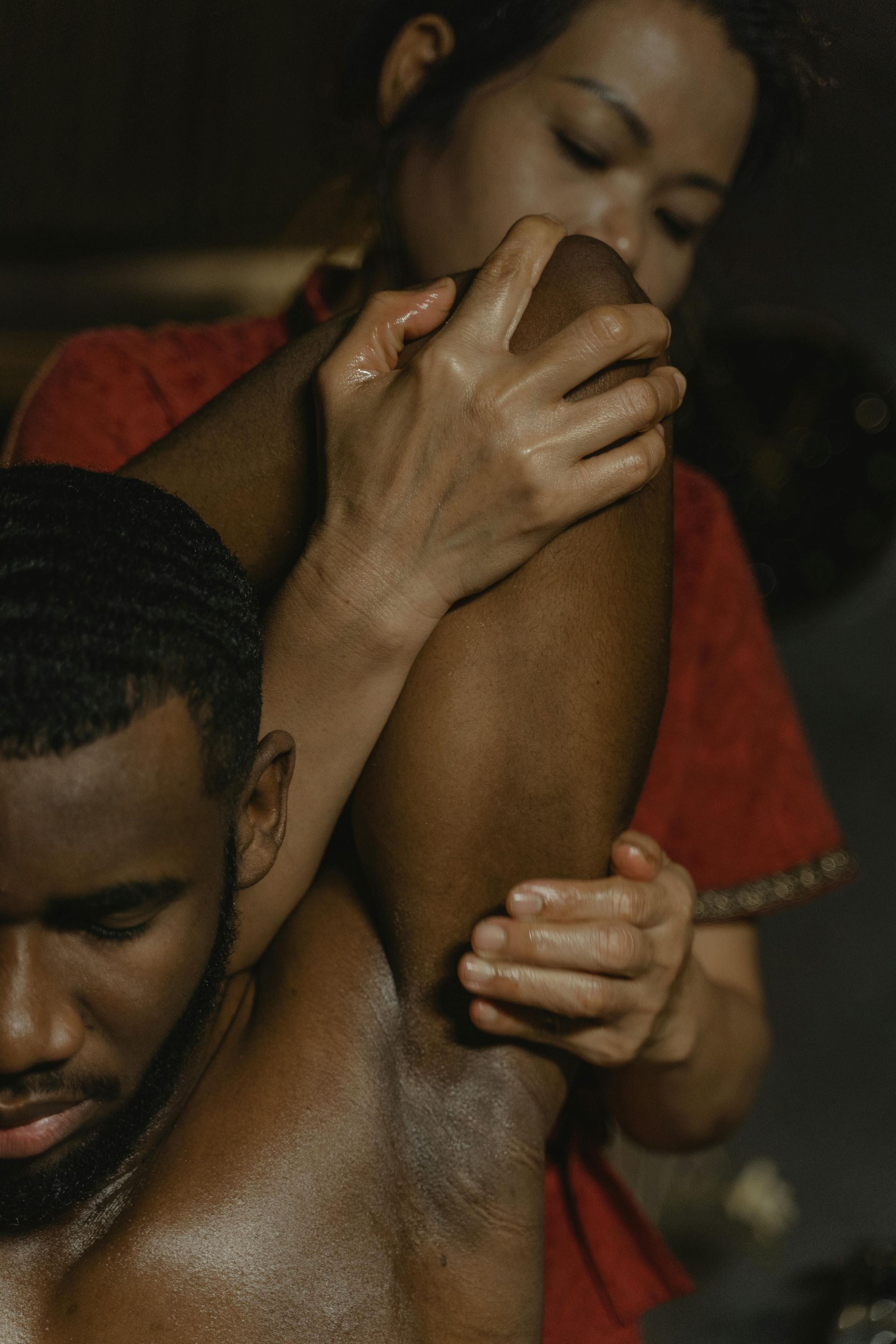 Person giving arm massage to another person, indoor setting.