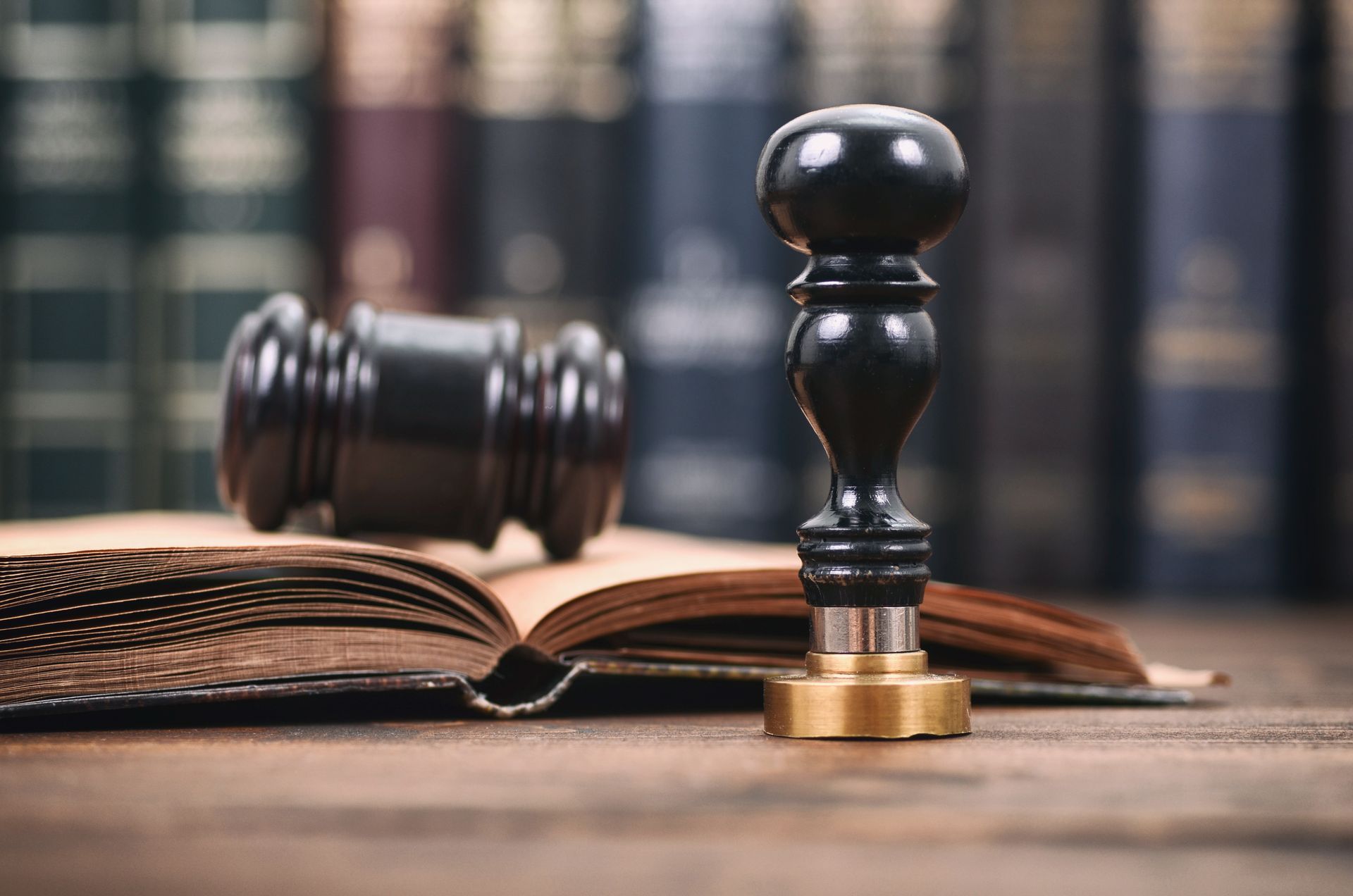 Law book with gavel and stamp on a wooden desk, courtroom-themed scene Law book with gavel and stamp on a wooden desk, courtroom-themed scene