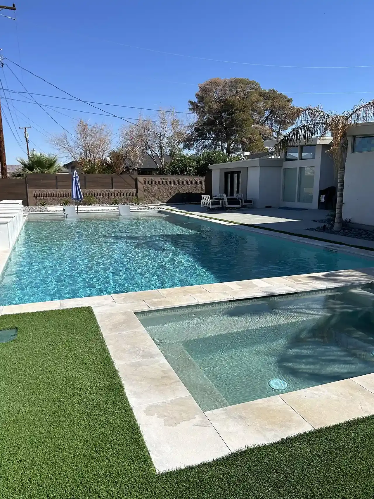 A large swimming pool with a hot tub in the middle of it.