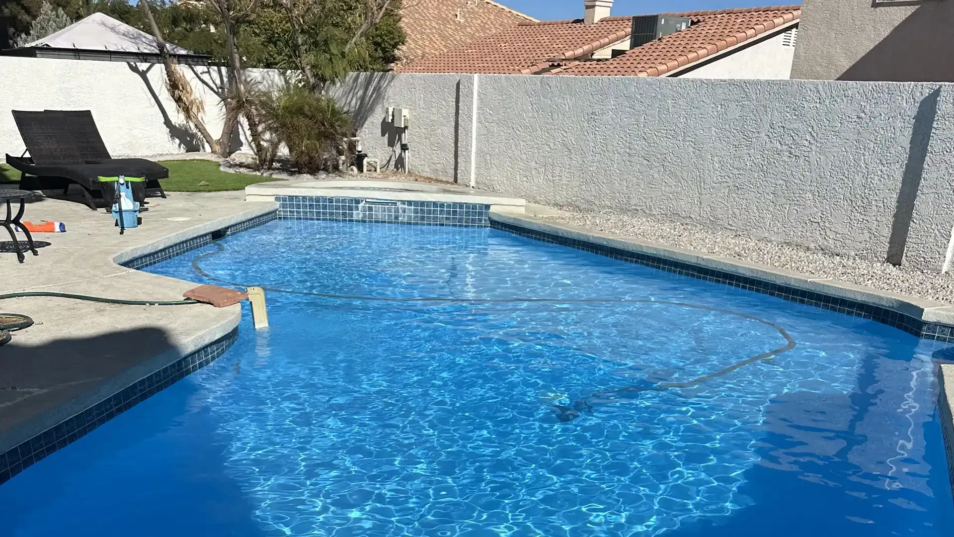 A large swimming pool in the backyard of a house.