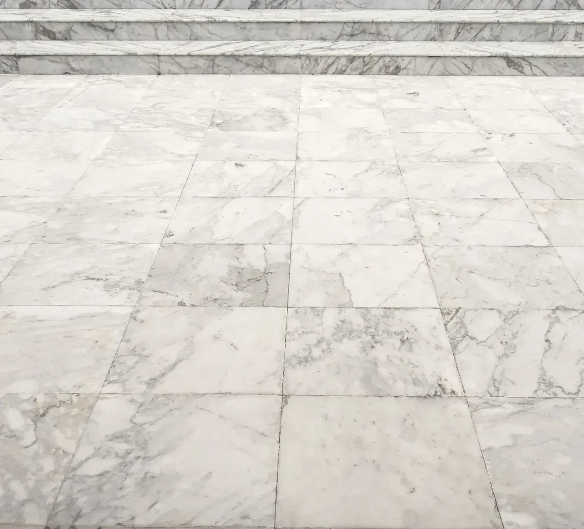 White marble tiled floor leading to steps.