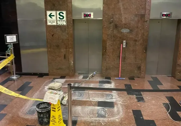 Elevator lobby with caution tape. Damaged floor around elevator entrance; a