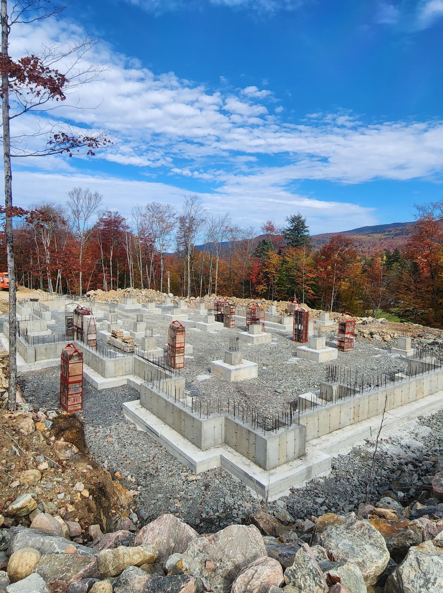 Un chantier de construction avec beaucoup de rochers et d'arbres en arrière-plan.