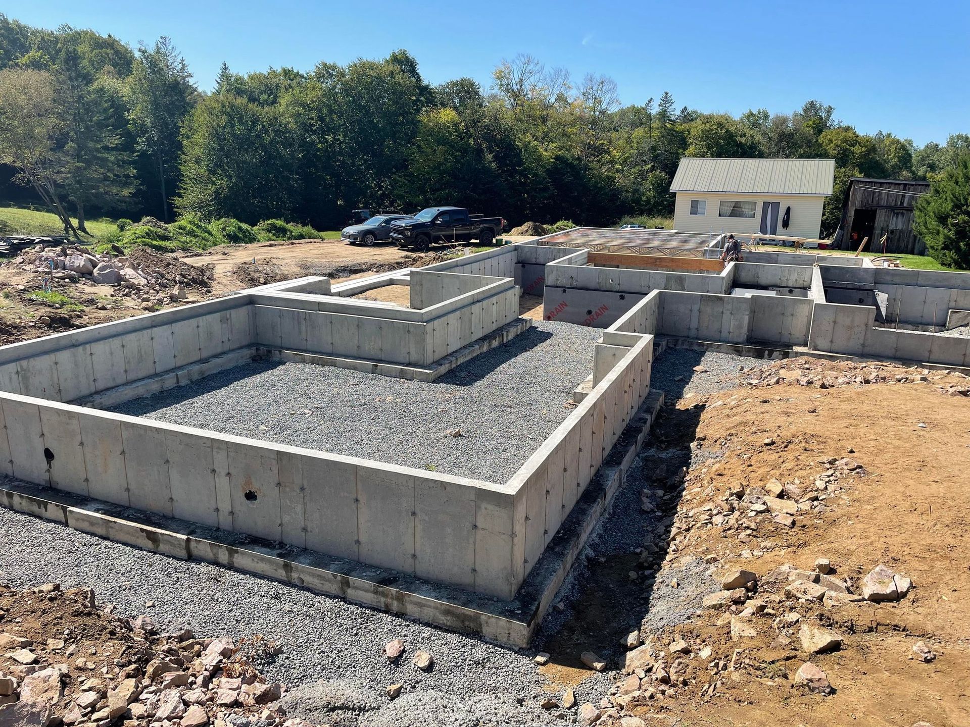 Une fondation en béton pour une maison est en cours de construction dans un champ de terre.