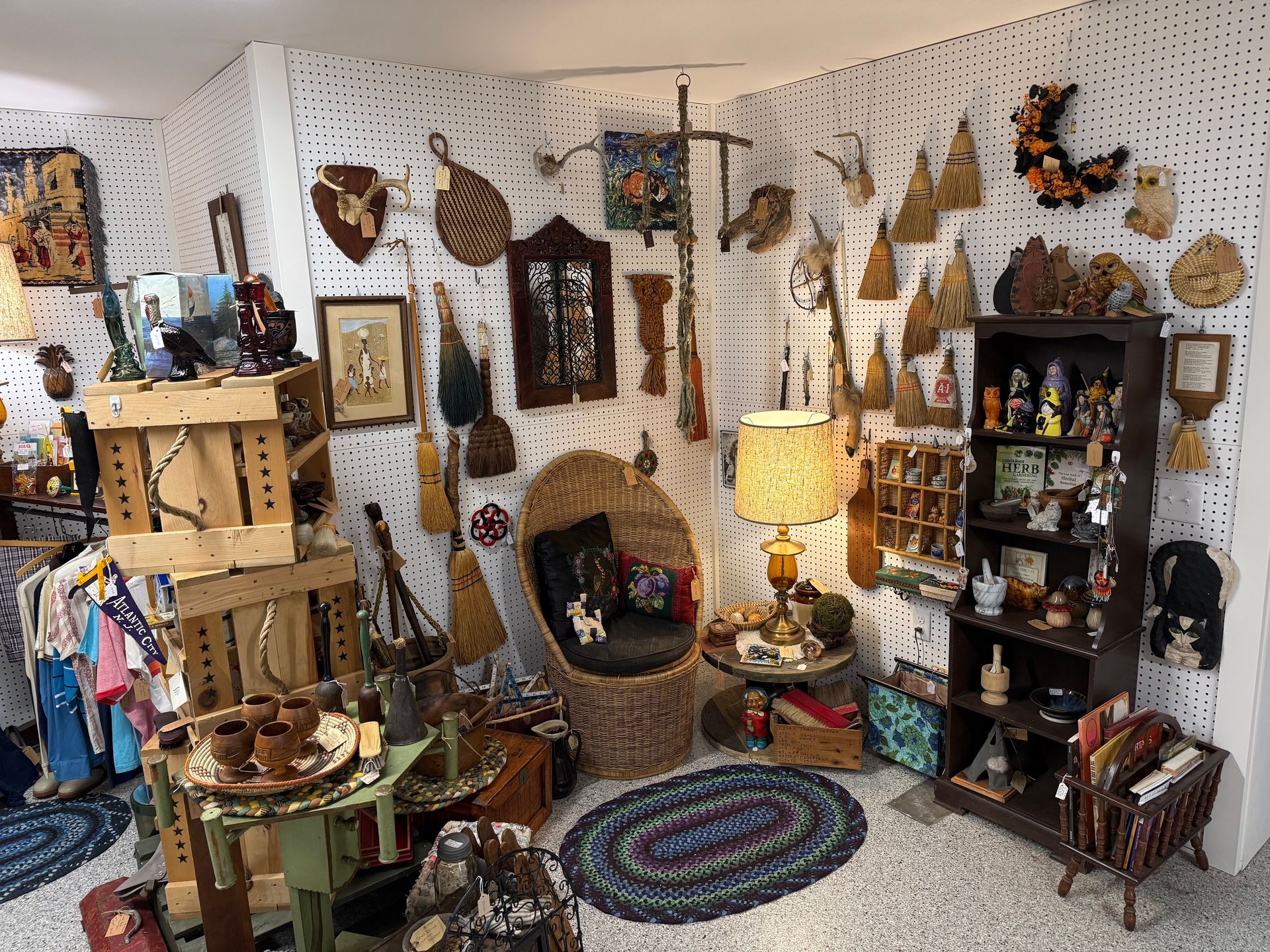 Cozy eclectic room with wall art, shelves, lamp, rug, and a small fireplace or niche.