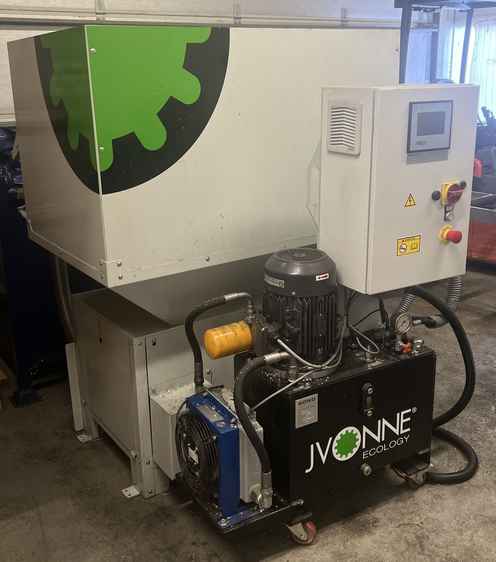 Industrial Jvonne machinery with a green gear logo, a control panel, and a hydraulic power unit in a workshop.
