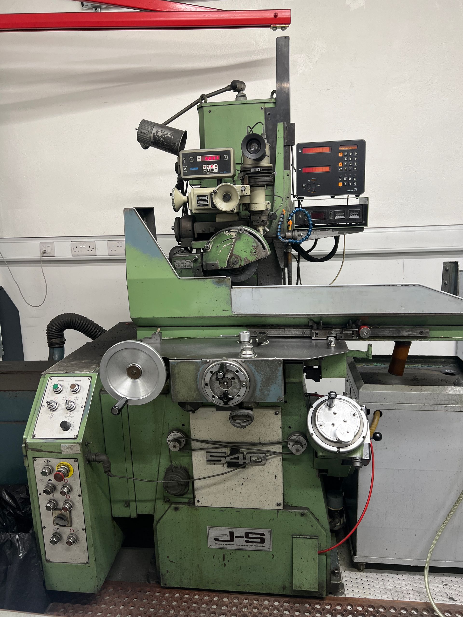 A mint green, industrial cylindrical grinding machine featuring a control panel, handwheels, and a digital readout unit.