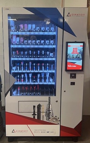 An industrial vending machine for machine tools and metalworking equipment, featuring a touchscreen and glass display.