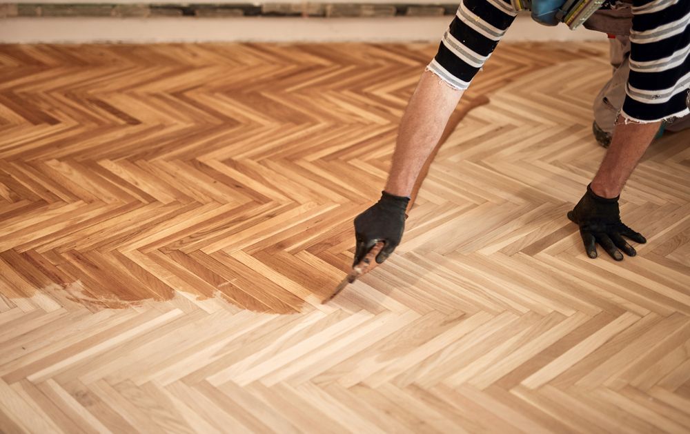 Person Applying Stain To A Herringbone Wood Floor — Scott Johnston Floor Sanding in Atherton Tablelands, QLD