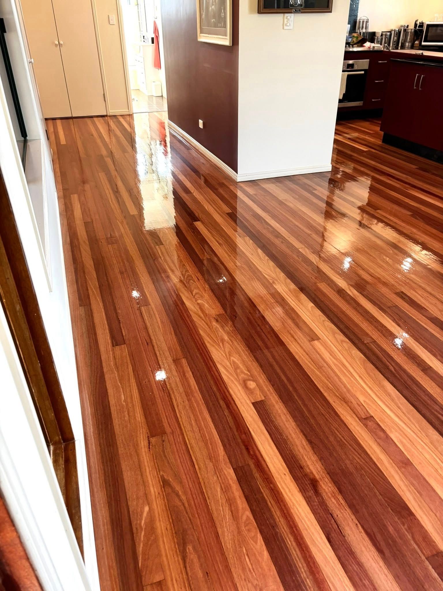 Shiny, Newly Finished Wooden Floorboards Reflecting Light — Scott Johnston Floor Sanding in Bentley Park QLD