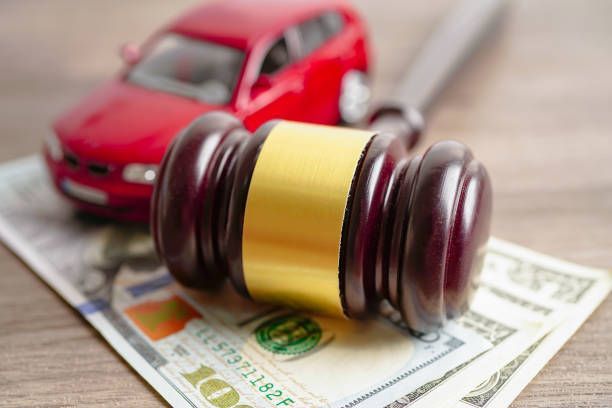 Car and gavel on a table with money, representing a car crash attorney in Glassboro NJ.