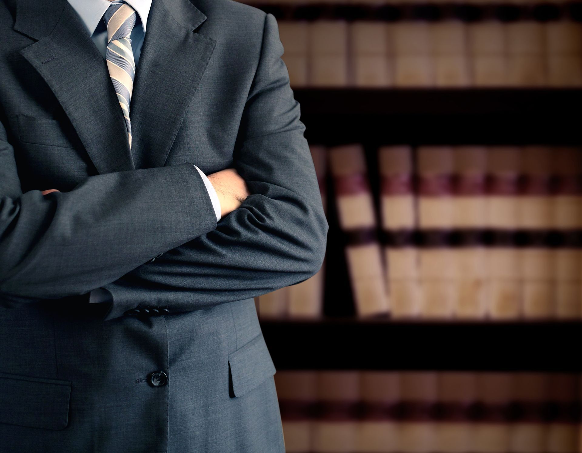 Close-up of lawyer showcasing workers compensation expertise, standing in front of law books.