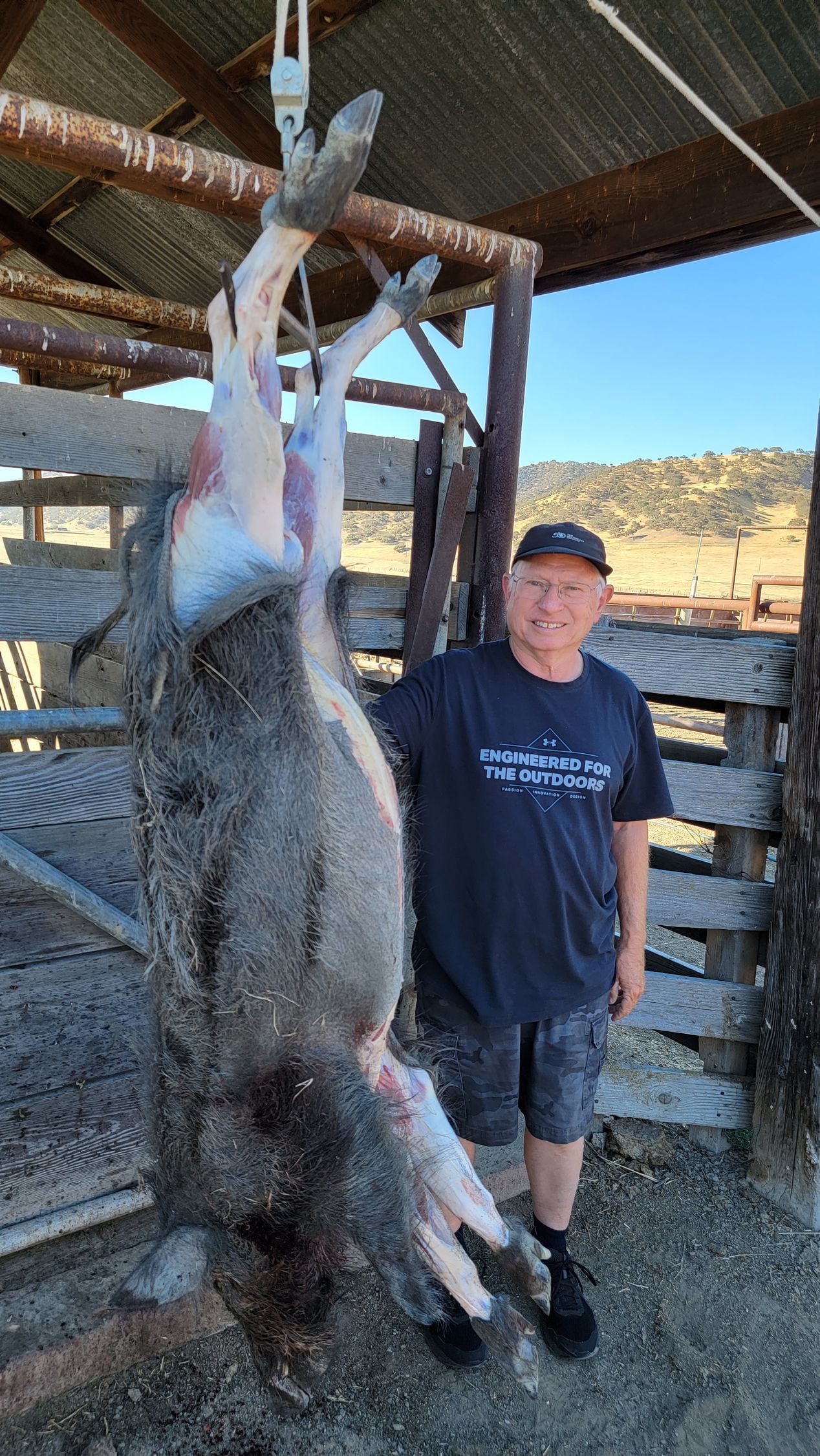 Hunter standing next to large wild pig taken in California during guided hunt