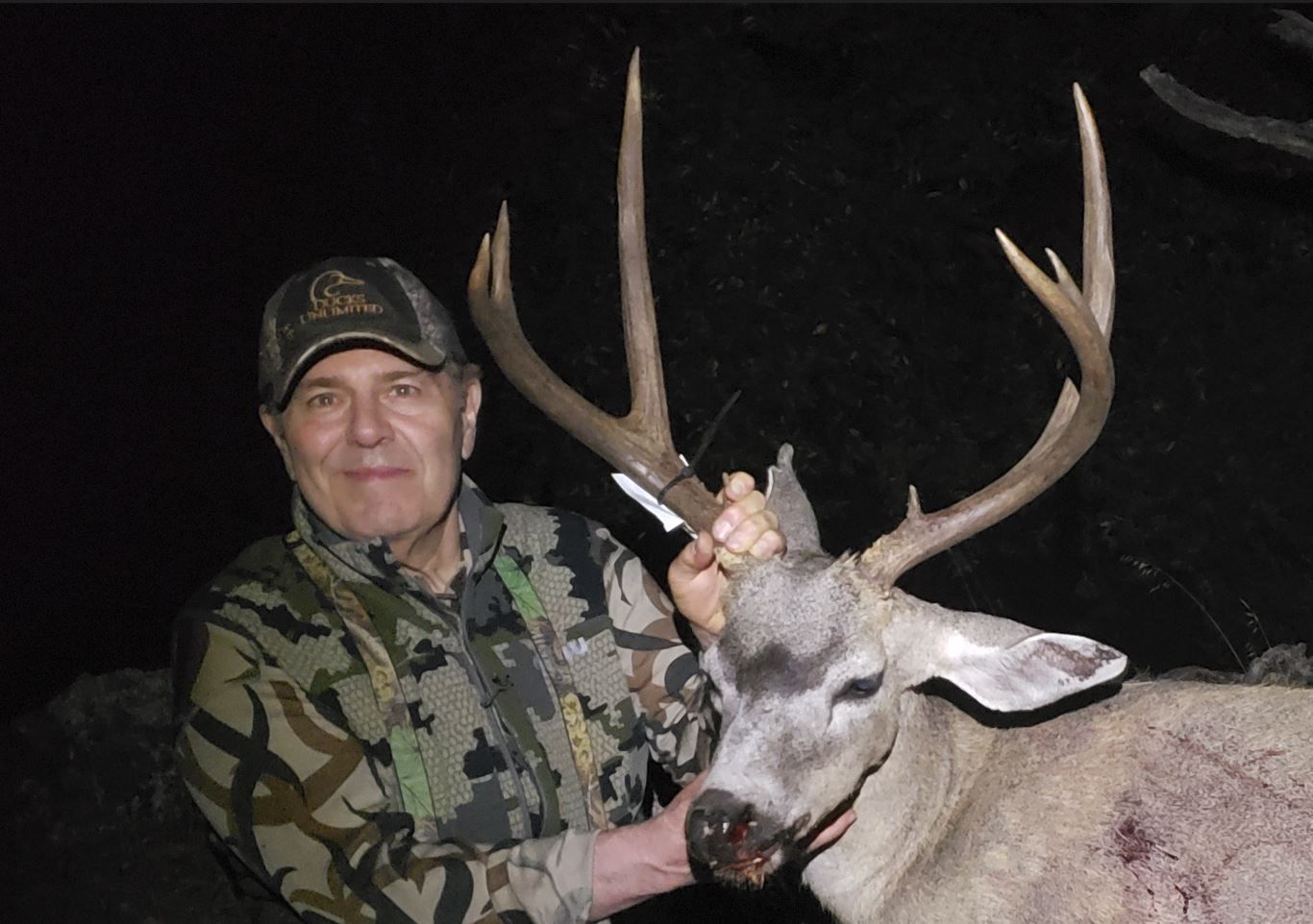 Hunter posing with mature blacktail buck during trophy hunt in California