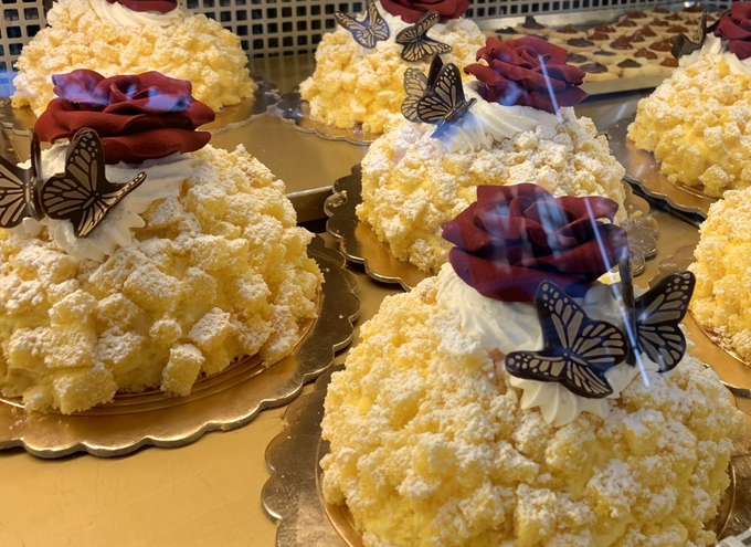 Torte ricoperte di glassa gialla, decorate con rose rosse e farfalle