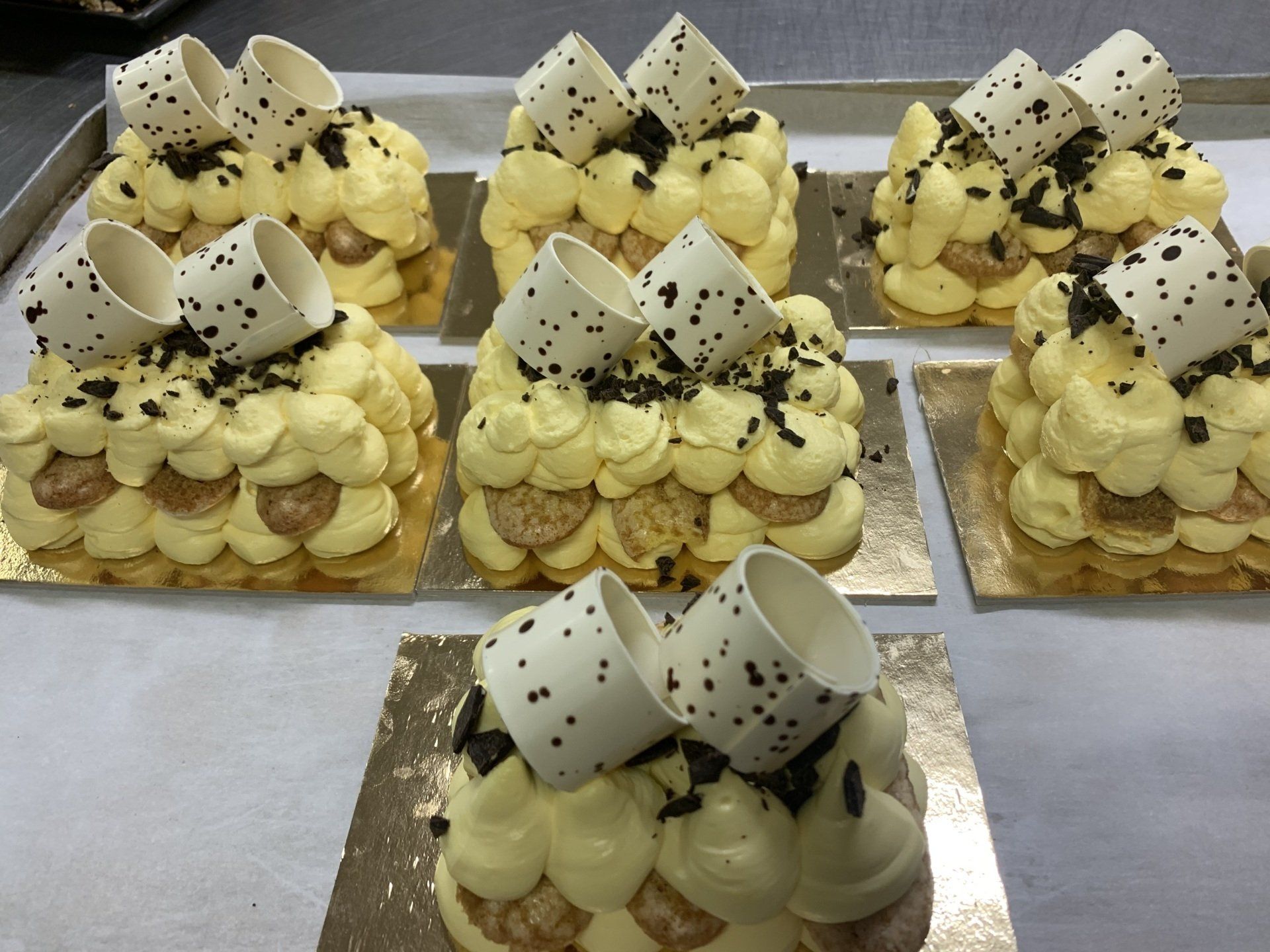 Sei piccole tortine da dessert, guarnite con panna e decorazioni di cioccolato 