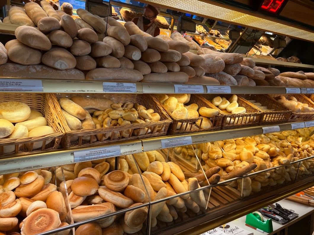 Gli scaffali del panificio sono pieni di pagnotte, baguette e panini assortiti
