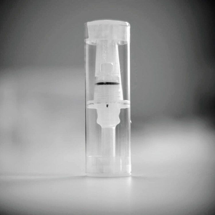 A clear plastic bottle with a white cap is sitting on a table.