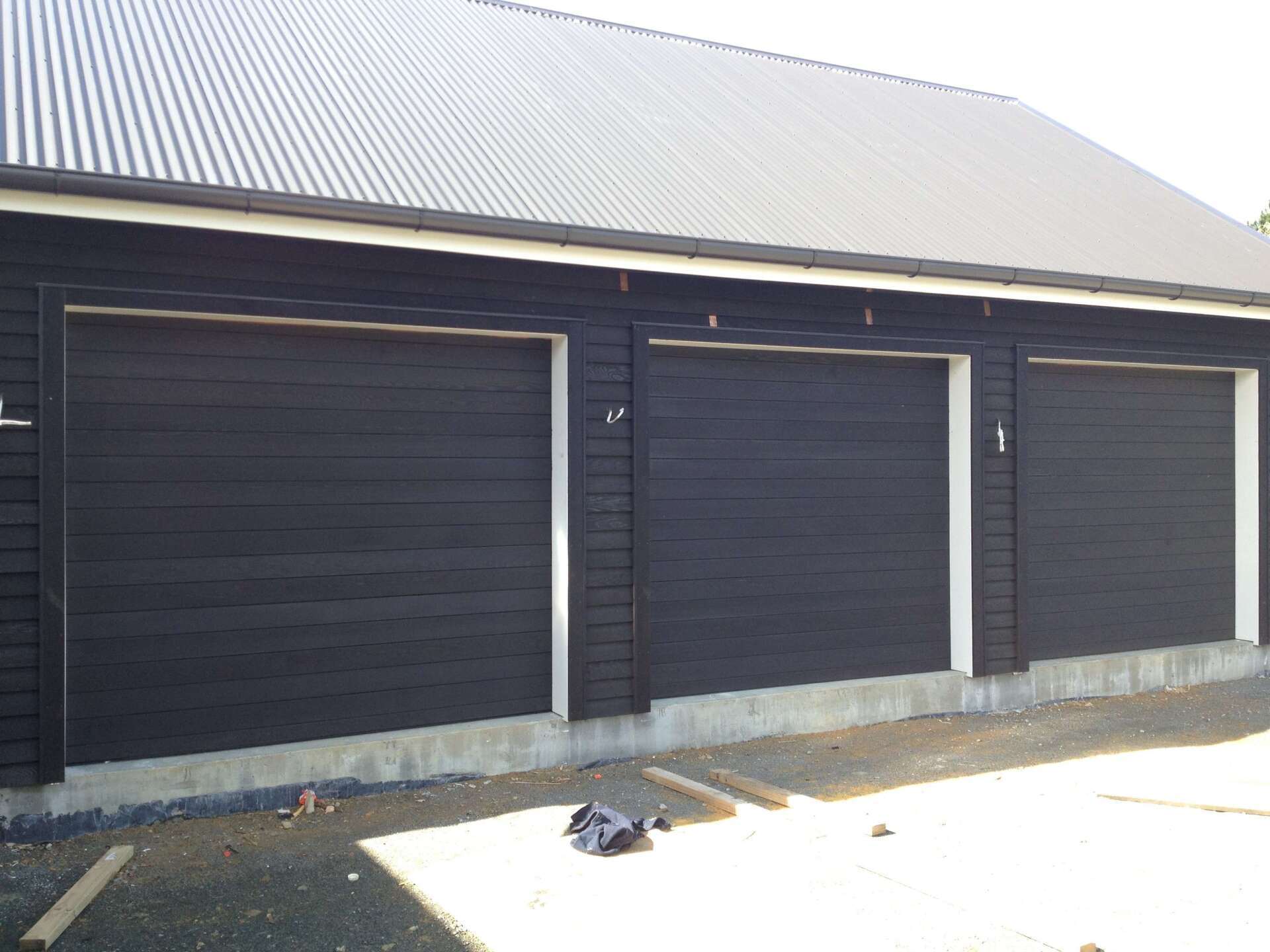 A row of black garage doors on a building