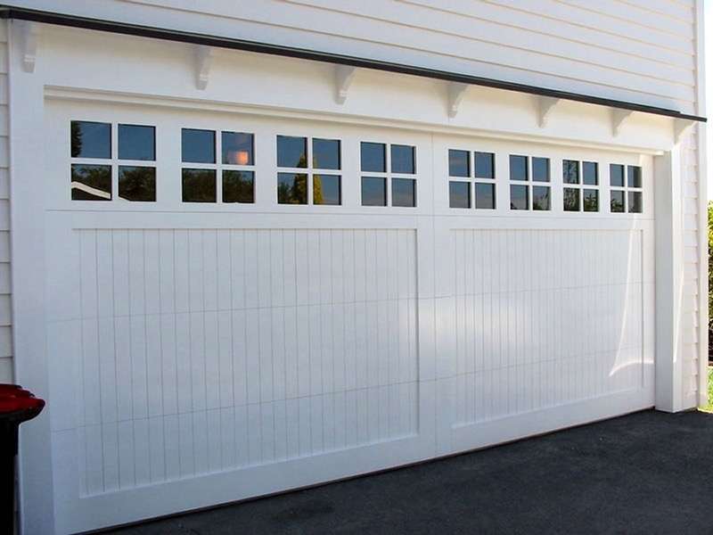 A white garage door with a lot of windows on it