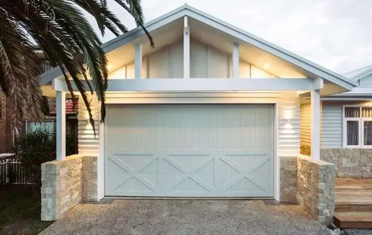 A house with a white garage door and a palm tree in front of it