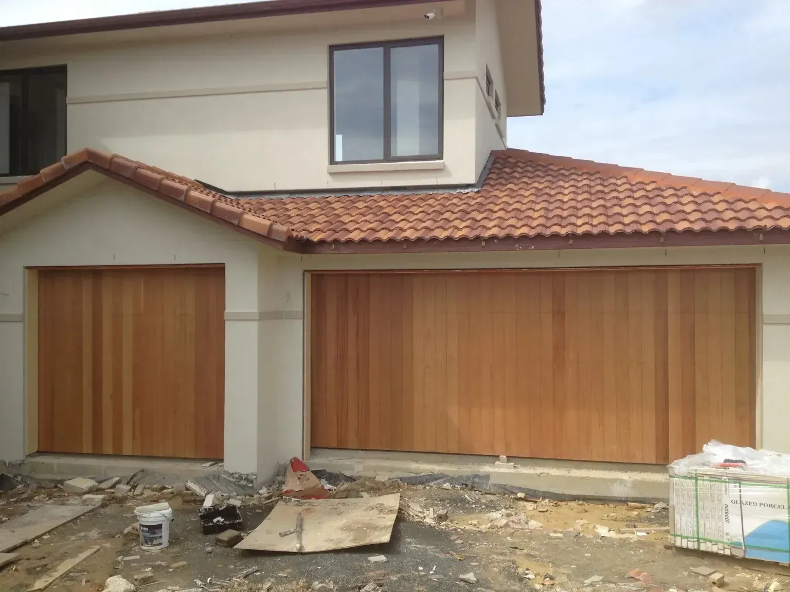 A large white house with a wooden garage door