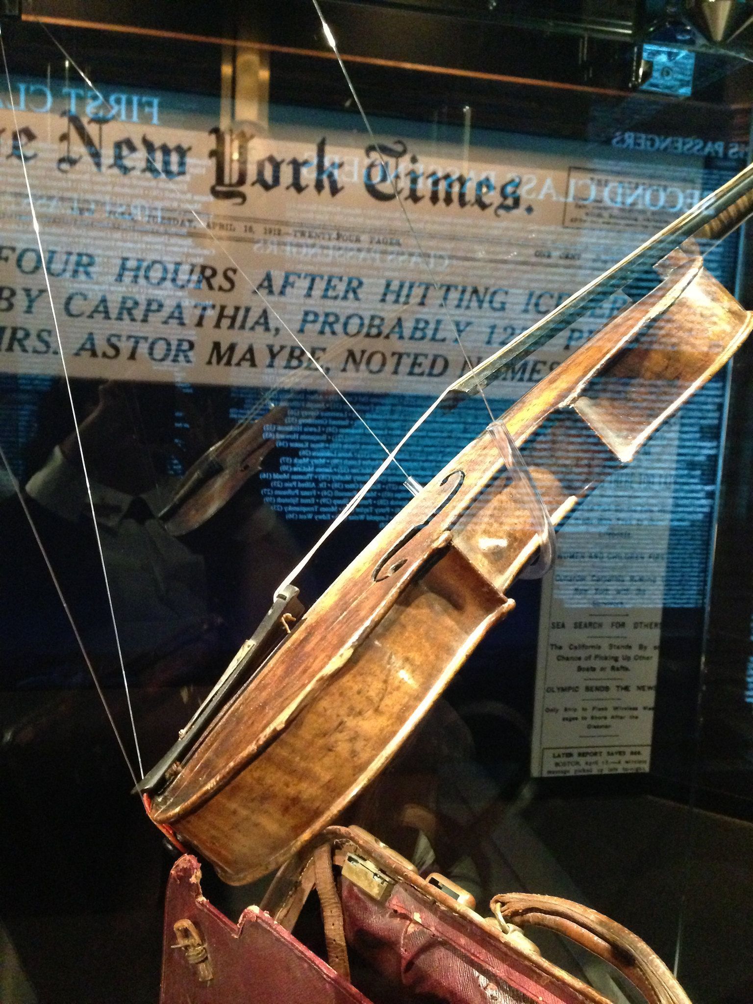 A violin is displayed in front of a new york times newspaper