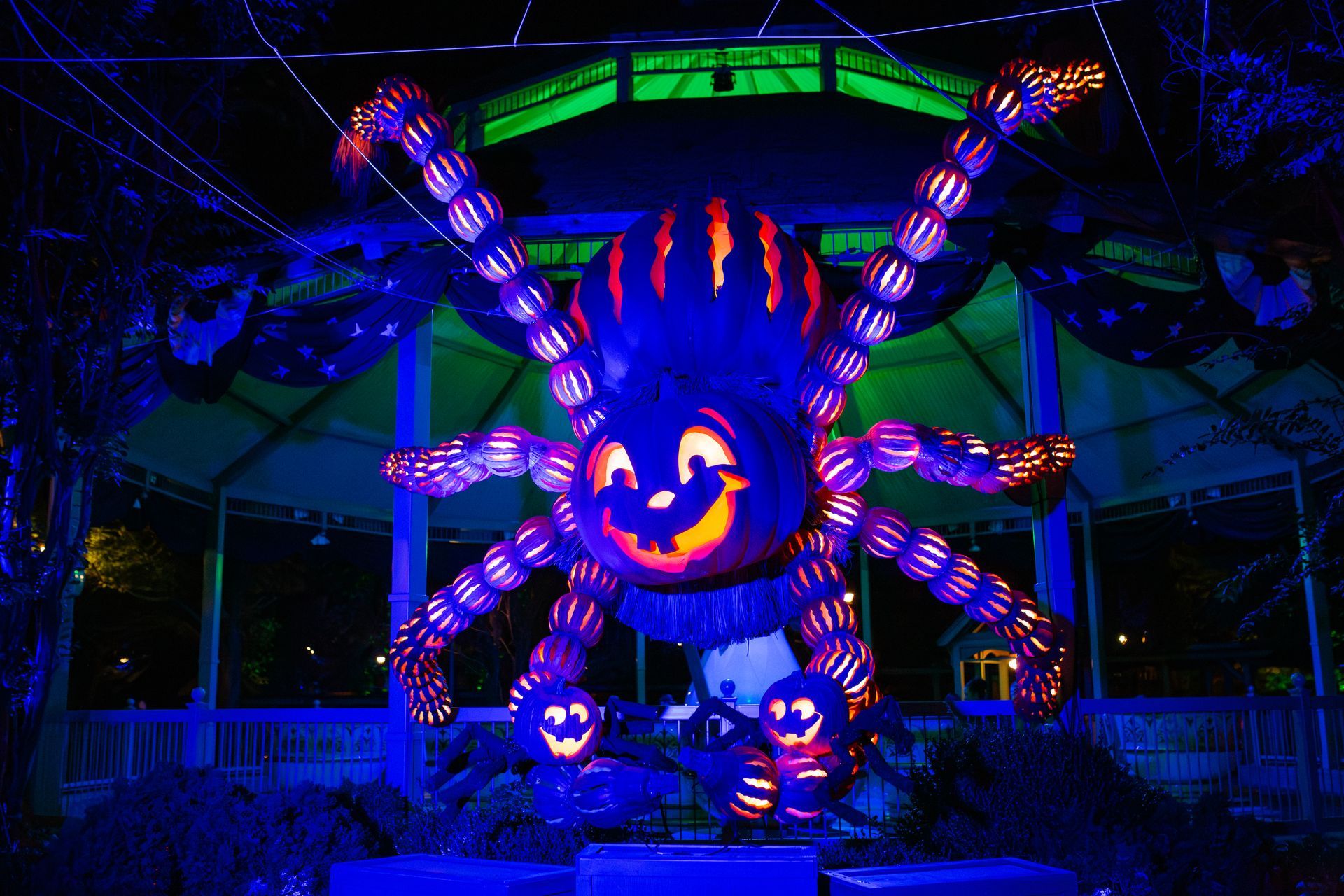 A large pumpkin with a face carved into it is glowing in the dark.