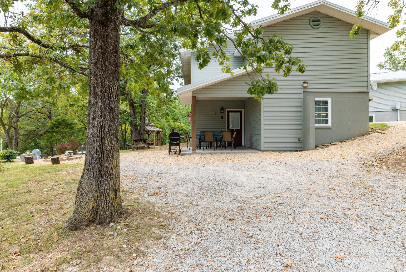 A house with a driveway and a tree in front of it.