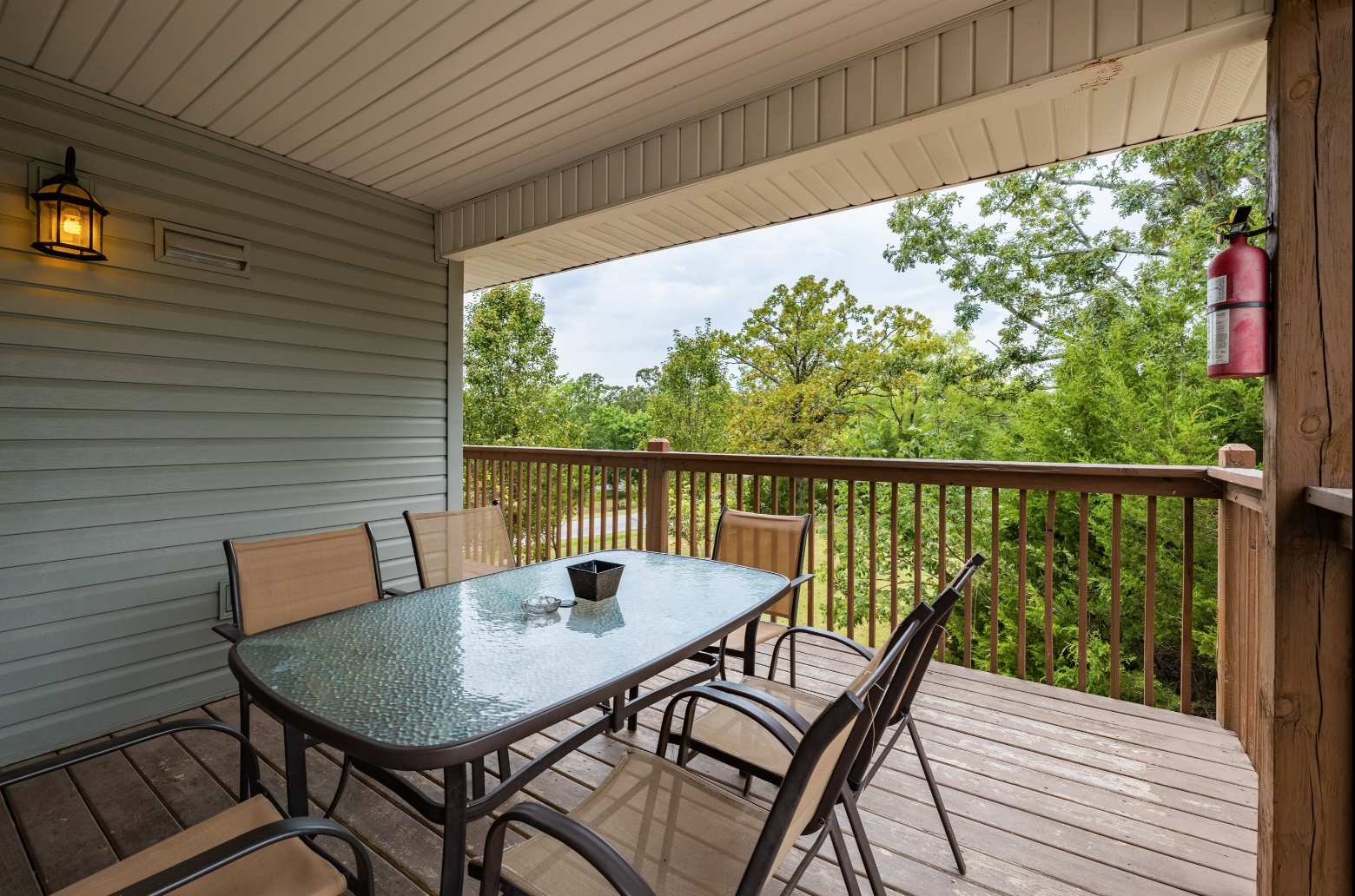 There is a table and chairs on the deck of a house.