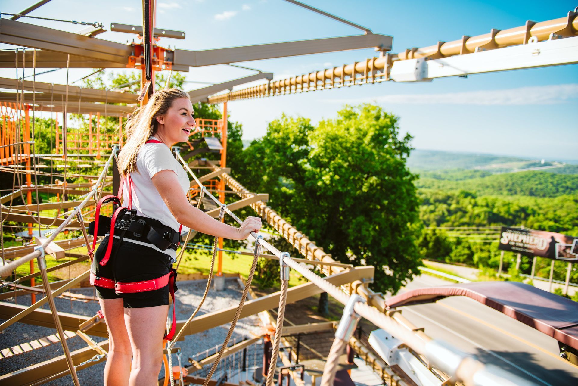 A woman is standing on top of a roller coaster.