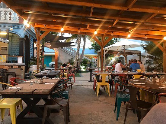 A restaurant with tables and chairs under a canopy.