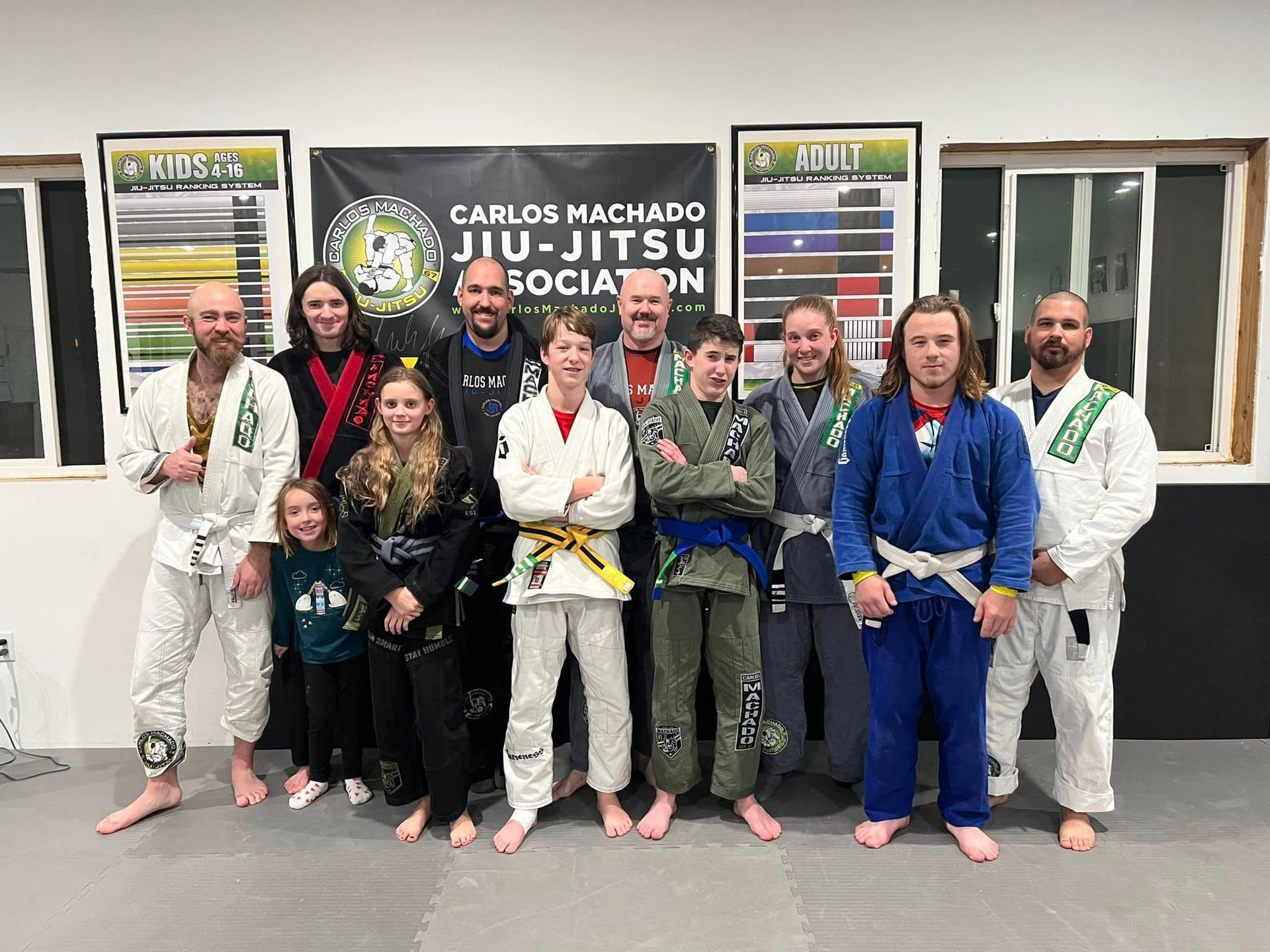 A group of people in karate uniforms are posing for a picture in a gym.