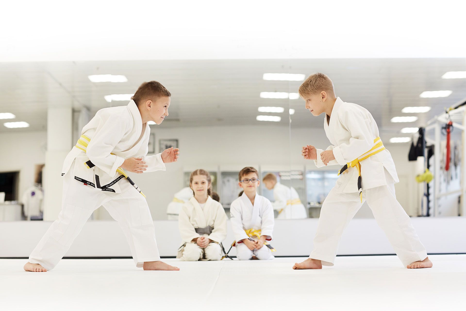 A group of young boys are practicing karate in a gym.