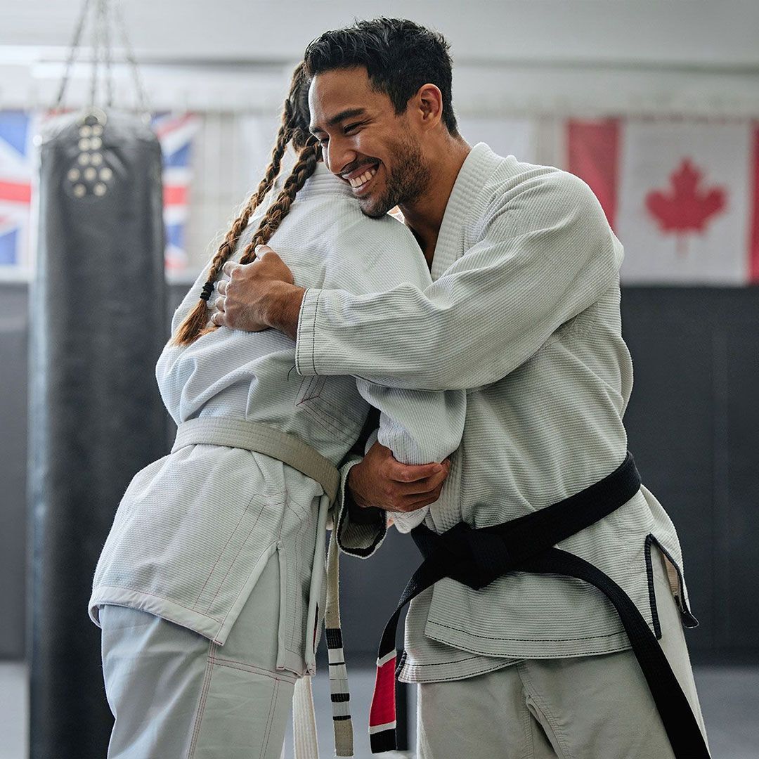 A man and a woman are hugging each other in a gym.